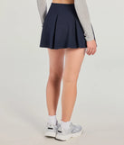 The Keeping It Cute Pleated Ponte Skort is a trendy women's bottom in navy blue, designed with modern details and alluring textures to complete chic outfits for 2025.