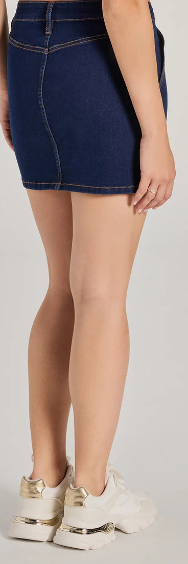 The Covetable Cutie High-Rise Denim Mini Skirt is a trendy women's bottom in dark denim wash, designed with modern details and alluring textures to complete chic outfits for 2025.