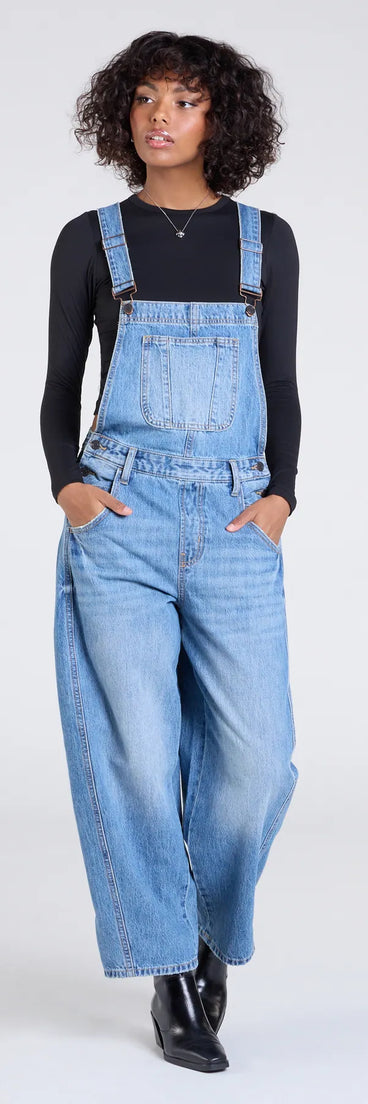 The Casual Aesthetic Baggy Denim Overalls in medium denim wash brings edge and energy to your vibe, ready to elevate any festival look or concert outfit.
