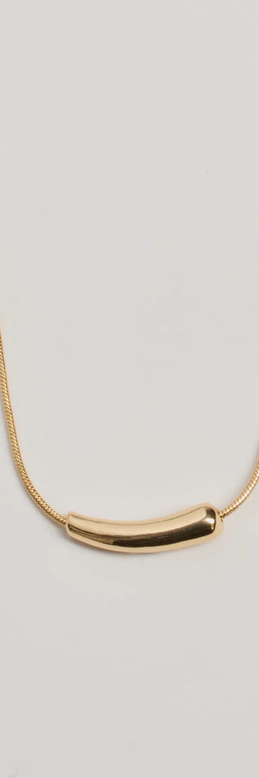 The Dainty Luxe Bar Charm Necklace in gold is a women's workwear piece offering a trendy style and unique accents, perfect for effortlessly creating an outfit-of-the-day look that transitions your office look to going-out ready.