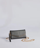 The Classically Chic Faux Leather Envelope Wristlet in black is a women's workwear essential with an elevated fabric and chic silhouette, ideal for layering and versatile enough to take your look from office chic to going-out ready!