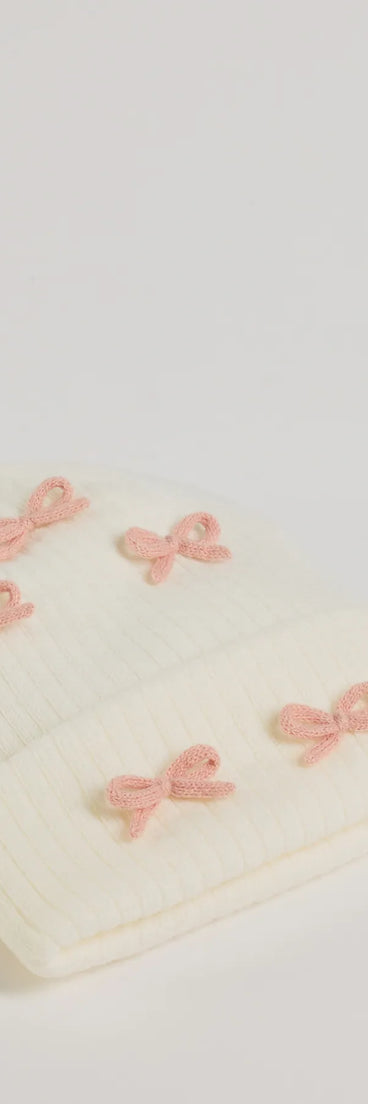 Add a touch of seasonal charm to your winter wardrobe with the Cozy Up Bow Detail Ribbed Knit Beanie, a white cold-weather accessory that effortlessly completes your seasonal looks!