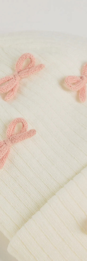 Add a touch of seasonal charm to your winter wardrobe with the Cozy Up Bow Detail Ribbed Knit Beanie, a white cold-weather accessory that effortlessly completes your seasonal looks!