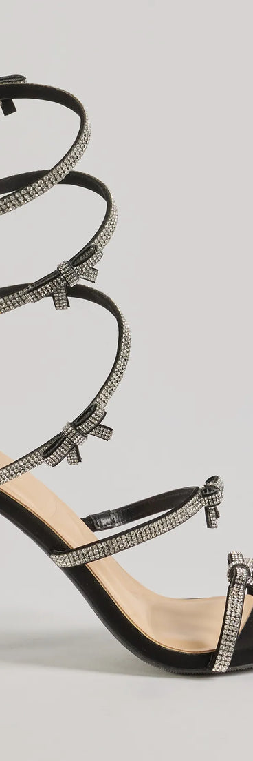 Elevate warm-weather looks with Glam Era Rhinestone Bow Spiral Strap Stiletto Heels in black, a pair of trendy sandals bringing chic, modern flair to every step.
