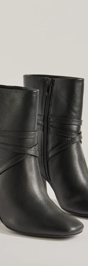 The Stylish Stride Strappy Faux Leather Booties are women's black shoes for work, featuring a sleek silhouette and cushioned sole for all-day comfort, and are a trendy choice for professional or business casual outfits.