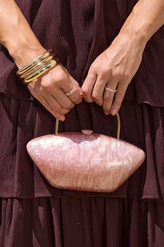 Discover women’s accessories featuring marbled handbags, sparkling rings, and elevated warm-weather styling.