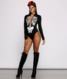 Sultry Babe Long Sleeve Skeleton Bodysuit styled by Windsor as a Women's Skeleton Costume including Rose Headband, Skeleton Face Gems, Halloween Costume Jewelry, Fishnet Stockings, and Black Knee High Lace Up Boots
