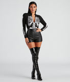 Women’s long sleeve skeleton print bodysuit with mock neckline styled with black faux leather shorts and latex thigh-high boots for a Halloween party outfit