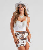 Rhinestone fringe corset top in white styled with a cow print mini skirt, bandana necklace, and rhinestone fringe cowboy hat for a women’s Halloween rhinestone cowgirl costume