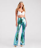 Adult mermaid costume from Windsor styled with a white embellished bra with rhinestones and pearl chains, metallic fish scale print flare pants, seashell crown, gold metallic heels, and costume jewelry.