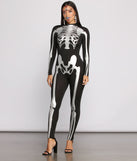 Ghoul and Glam Skeleton Face Gems styled by Windsor as a Women's Skeleton Costume including Large Rhinestone Cross Earnings, Skeleton Catsuit, and Black Heels